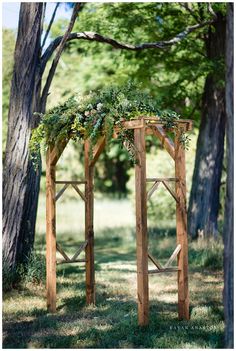 an outdoor wooden arbor with greenery on it