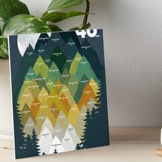 a poster with trees and mountains on it art boarder next to a potted plant