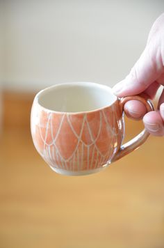 a person holding a coffee cup in their hand