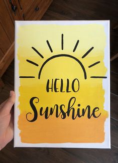 a hand holding up a yellow and black card with the words hello sunshine on it