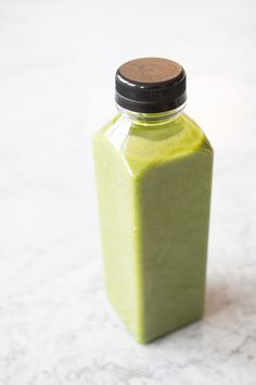 a green bottle sitting on top of a white counter