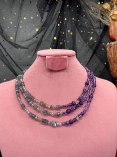 🌸 Materials: Amethyst, Labradorite, Cubic Zirconia, Stainless Steel 💜 Embrace a balance of mystery and elegance with our "Purple Fog" necklace, a three-row design that combines the depth of amethyst with the cool, shifting tones of labradorite. This dual-side style celebrates contrast, enhancing any look with its unique interplay of vibrant purple and soft gray hues. 🌸 Stone Selection: 💜 Amethyst: Smooth and faceted round beads, nuggets, and sparkling purple cubic zirconia add depth and brilliance to one half of the necklace. 💫 Labradorite: Square and round Heishi labradorite beads alongside faceted round beads provide a smoky, iridescent contrast, catching light with subtle flashes. 🌸 Design Details: ✨ Half-and-Half Design: This three-row necklace offers a striking split between war Labradorite Necklace, Gift Suggestions, Labradorite Beads, Labradorite Necklaces, Vibrant Purple, Beaded Necklaces, Round Beads, Artistic Designs, The Necklace