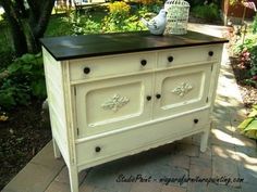 an old dresser painted white with black top