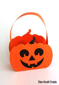 an orange halloween basket with pumpkins in it on a white surface, ready to be used as a trick or decoration