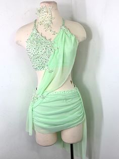 a mannequin wearing a green dress with beading on it's chest