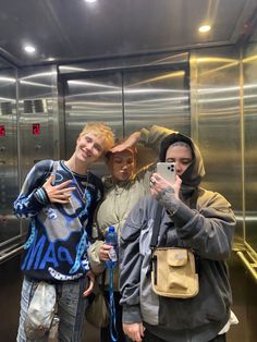 three people taking a selfie in an elevator