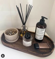 a wooden tray topped with bottles and candles