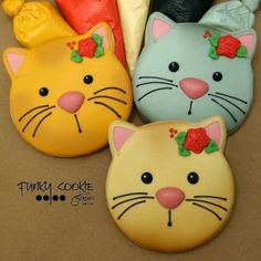 four decorated cookies in the shape of cats