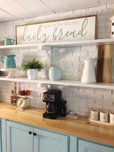 a kitchen with blue cabinets and shelves filled with coffee pots, mugs and other items