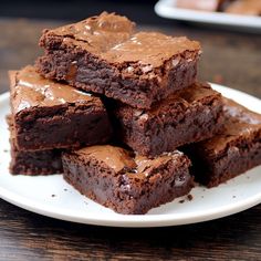 chocolate brownies stacked on top of each other on a white plate