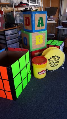 several different types of toys are sitting on the floor in an office area with boxes and bins