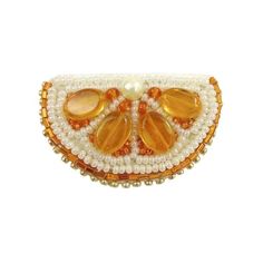 an orange and white beaded brooch with two leaves on it's side