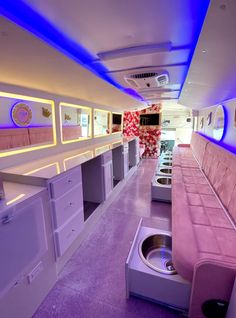 the interior of an airplane with pink couches and white cabinets on either side of it