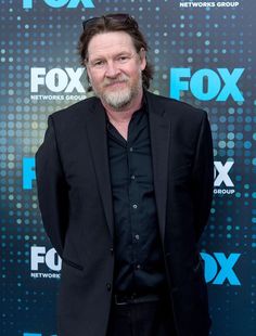 a man in a black suit and sunglasses on the red carpet at fox network's network