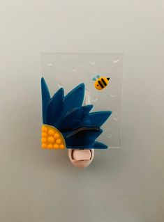 a lego head with corn on the cob and two bees flying around in front of it