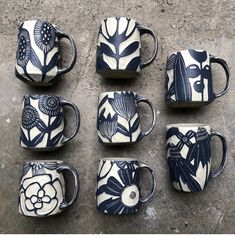 six blue and white coffee mugs sitting next to each other on top of a table