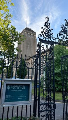 an iron gate in front of a building with a sign on it that says cambridge university