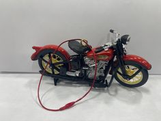 a toy motorcycle with a red rope attached to it