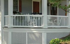 a porch with white railing and chairs on it