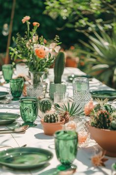 the table is set with green glassware and succulents