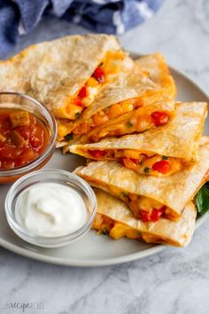 quesadillas on a plate with salsa and sour cream