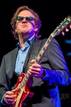 a man playing an electric guitar on stage