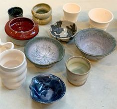 many different bowls and cups on a table