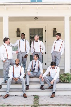 a group of men wearing ties and suspenders posing for a photo on the steps