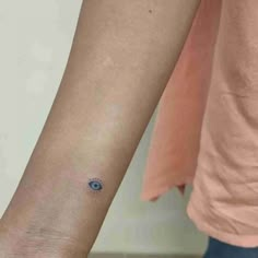 a woman's arm with an evil eye tattoo on the left side of her arm