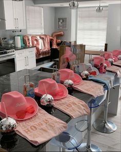 a table with pink hats on top of it and balloons hanging from the ceiling in the background