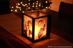 a candle holder with two pictures of people on it and the words anniversary written in white