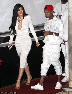 the two people are walking together in white outfits