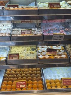 a display case filled with lots of different types of doughnuts and pastries