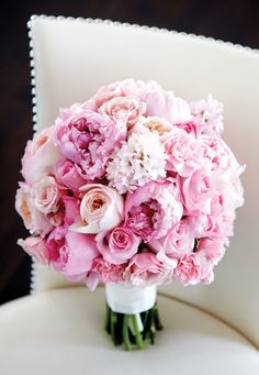 a bouquet of pink flowers sitting on top of a white chair