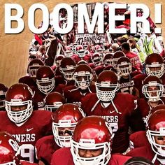 a large group of football players standing in front of a wall with the words boomer on it