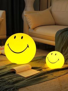 two yellow smiley face lamps sitting on top of a rug next to a couch and chair