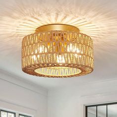 a light that is hanging from the ceiling in a room with white walls and windows