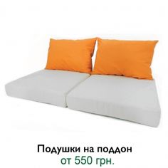 two orange pillows sitting on top of each other next to an advertisement for the company