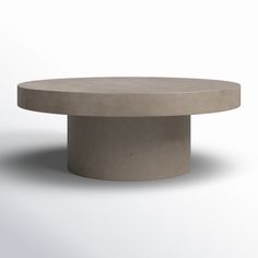 a round concrete table sitting on top of a white floor