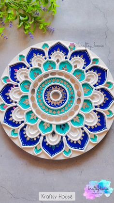 a blue and white plate sitting on top of a table next to some green plants