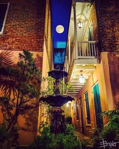 an apartment building at night with lights on the balconies and plants growing outside