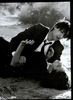 two people in suits are laying on the ground