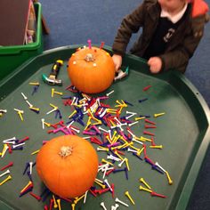 two orange pumpkins sitting on top of a green tray with sprinkles