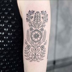 a black and white flower tattoo on the arm