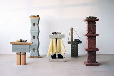 four different types of sculptures on display in a room with white walls and concrete flooring