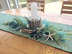 the table is set with an ocean themed centerpiece and candlestick holder on it