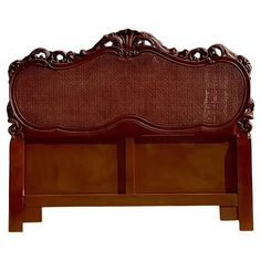 a wooden bed frame with intricate carvings on the headboard