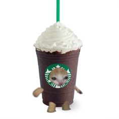 a starbucks cup with whipped cream and a dog face on the side, holding a green straw