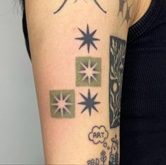 a woman's arm with tattoos on it that include stars, clouds and trees