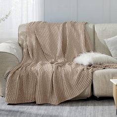 a couch with a blanket on it in a living room